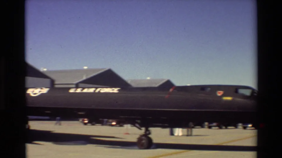 1981 Beale AFB home-movie frame showing the side of a parked SR-71 Blackbird with U.S. Air Force markings near hangars.