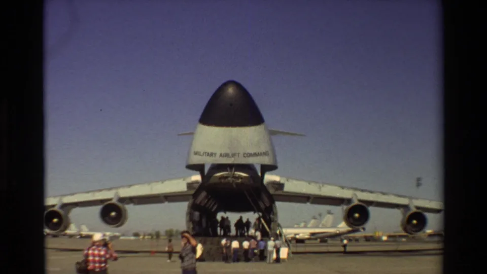 A C-5 Galaxy at Beale AFB appears with its rear cargo door open as visitors gather beneath the tail section.