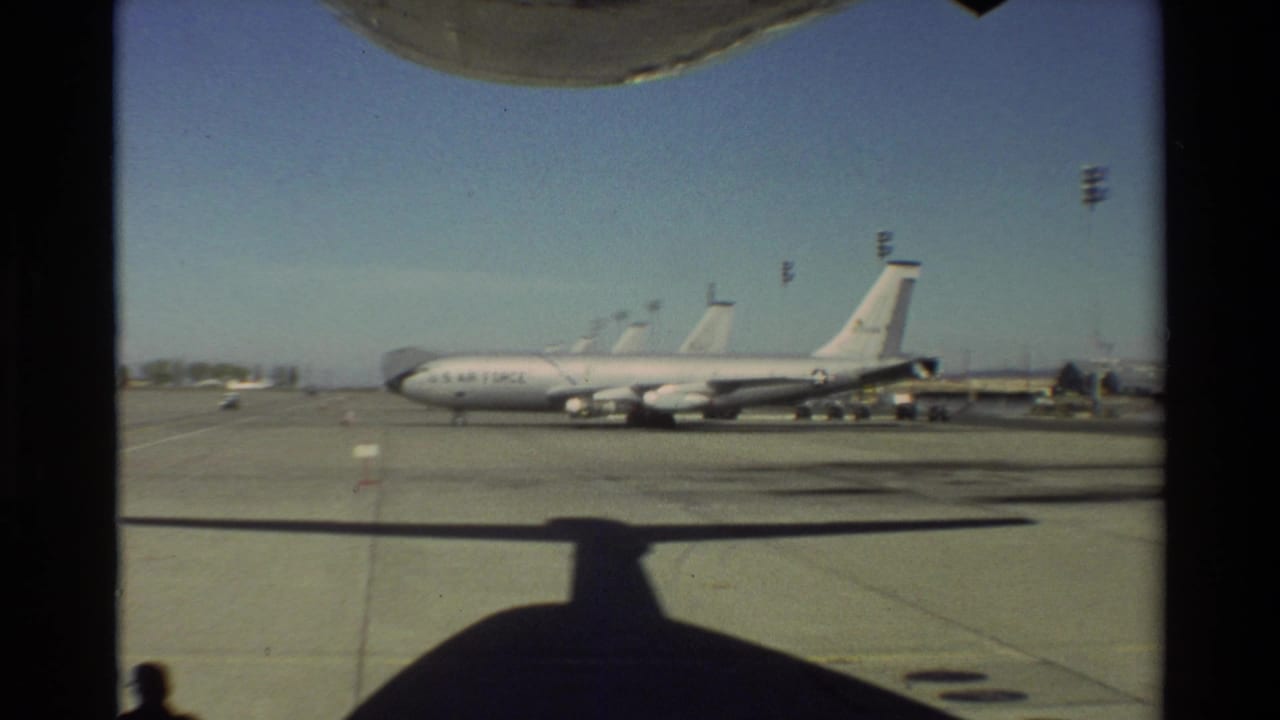 1981 Beale AFB view of a U.S. Air Force aircraft on the tarmac, framed from inside another aircraft with shadow across the pavement.