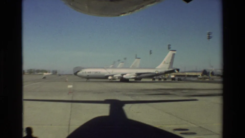 1981 Beale AFB view of a U.S. Air Force aircraft on the tarmac, framed from inside another aircraft with shadow across the pavement.