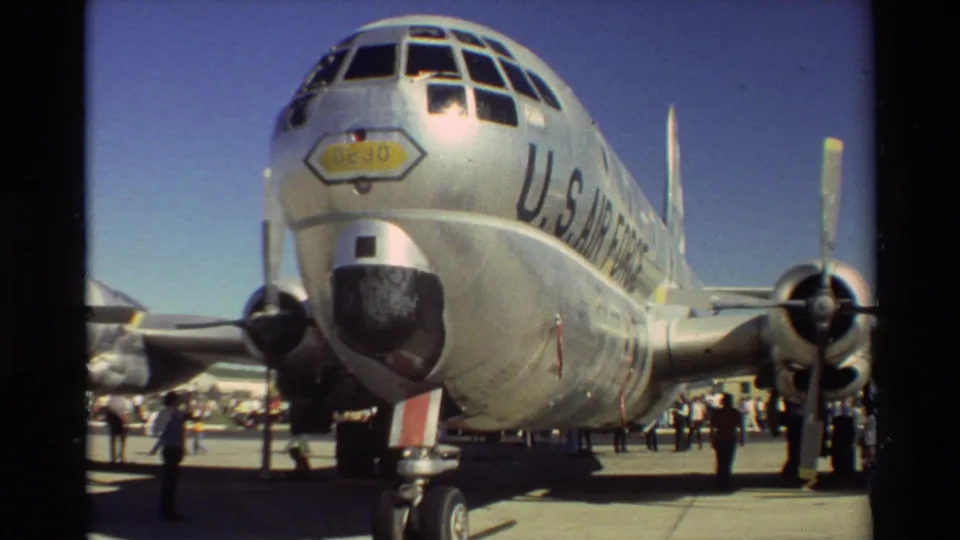Close 1981 Beale AFB home-movie view of a large silver U.S. Air Force propeller aircraft, with visitors standing around it.