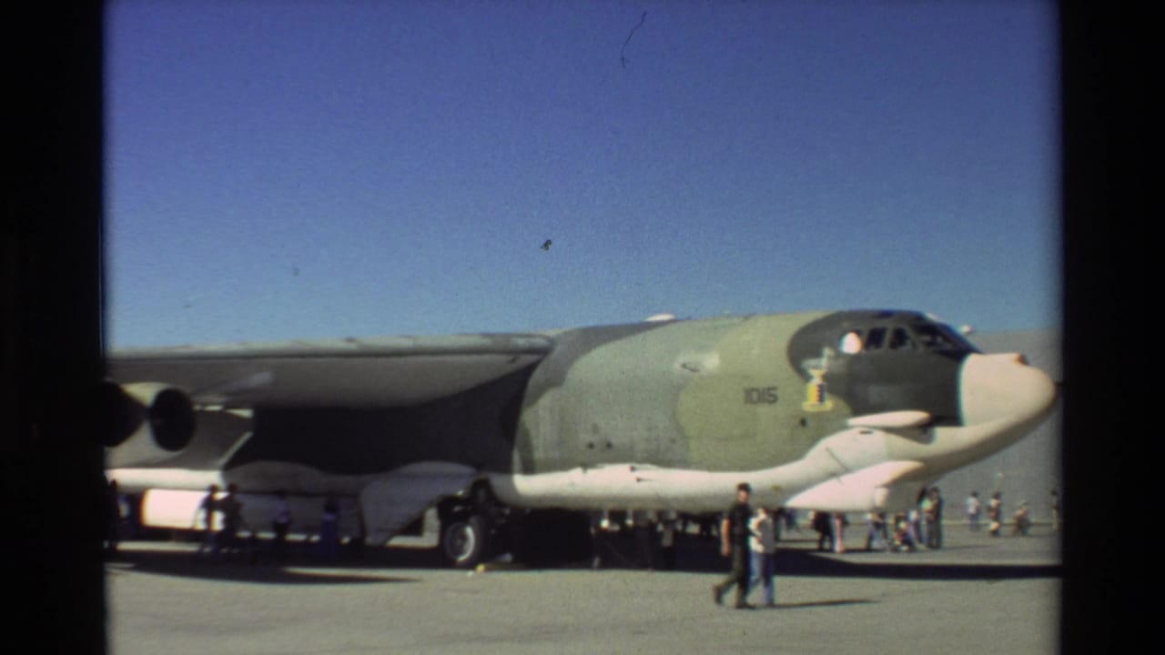1981 Beale AFB frame showing the nose and wing of a large green Air Force aircraft with visitors nearby.