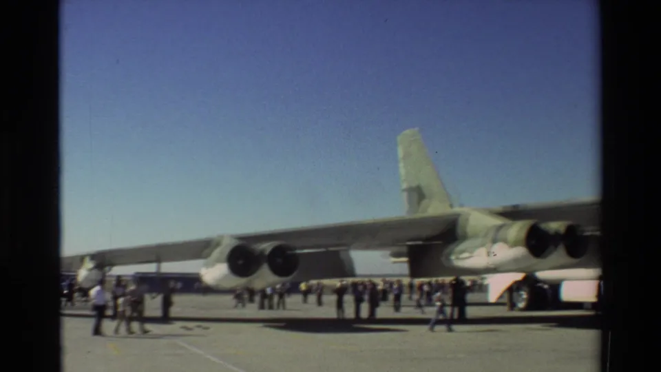 1981 Beale AFB frame showing visitors walking near the wing, engines, and tail of a large Air Force aircraft.