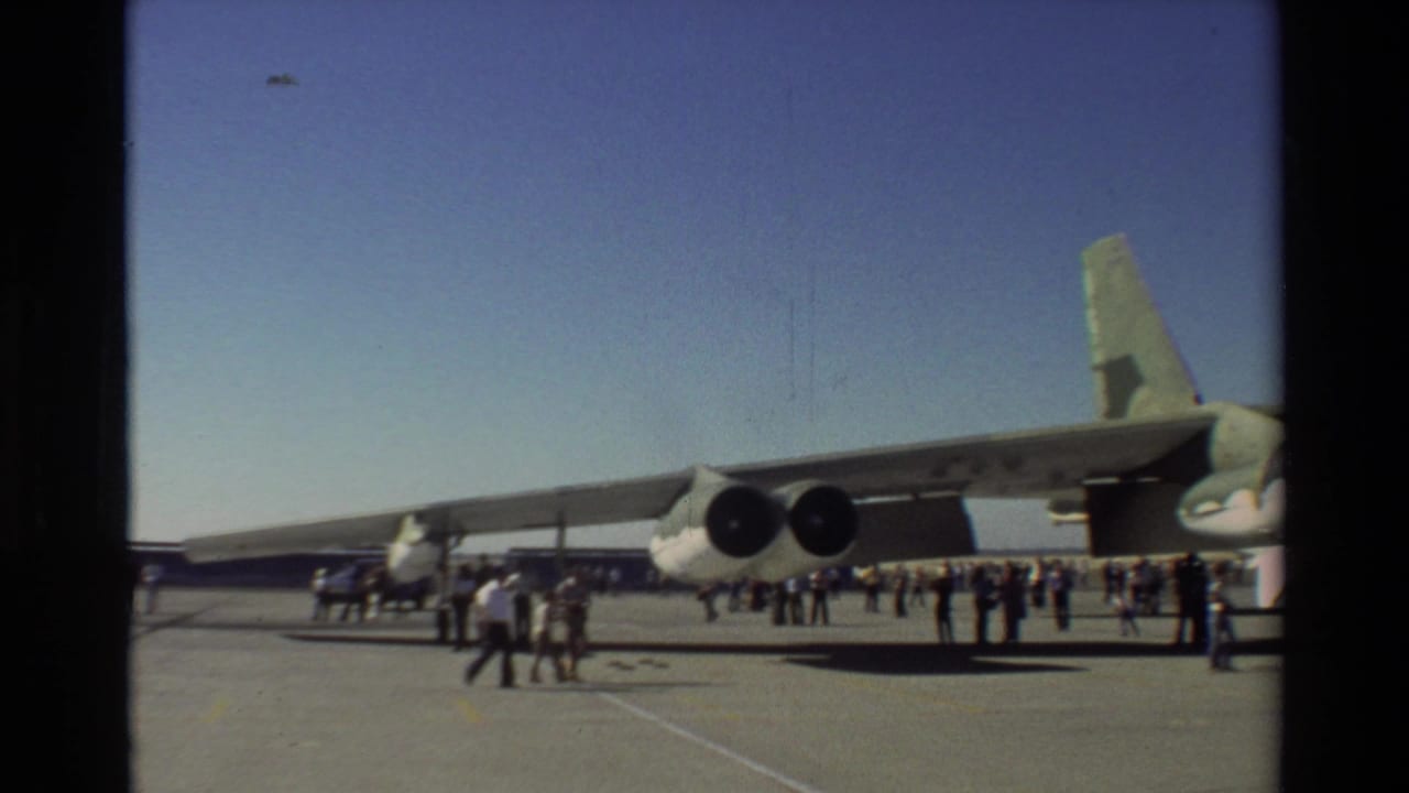 1981 Beale AFB footage shows a wide view of a B-52 bomber on the tarmac with groups of visitors standing near the engines and wing.