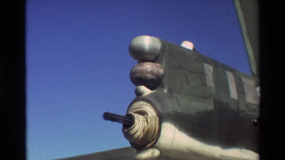1981 Beale AFB 8mm frame showing a close aircraft detail with a protruding gun or turret assembly against a clear blue sky.