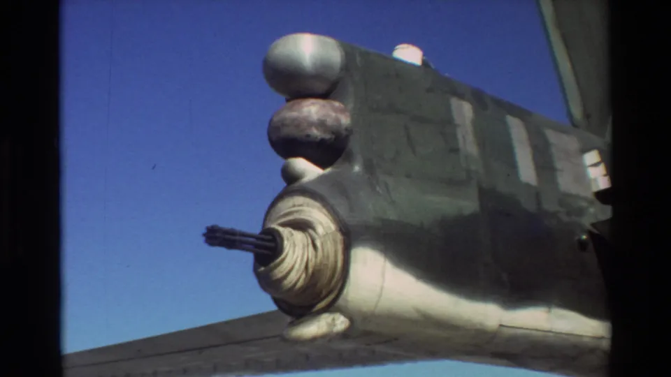 Close 8mm view of a military aircraft detail at Beale AFB, with a barrel-like assembly and rounded fittings visible against sky.