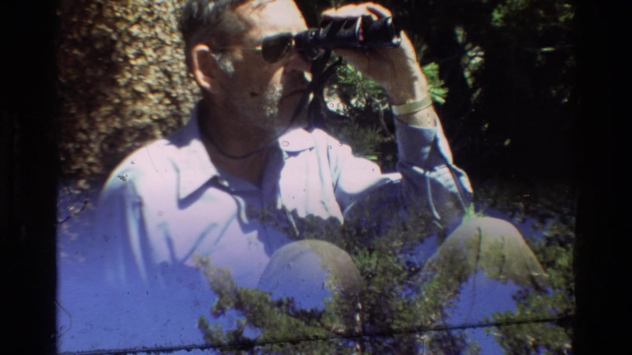 A seated man with binoculars appears partly overlaid with sky and conifer branches, consistent with 8mm film transition or exposure artifacts.