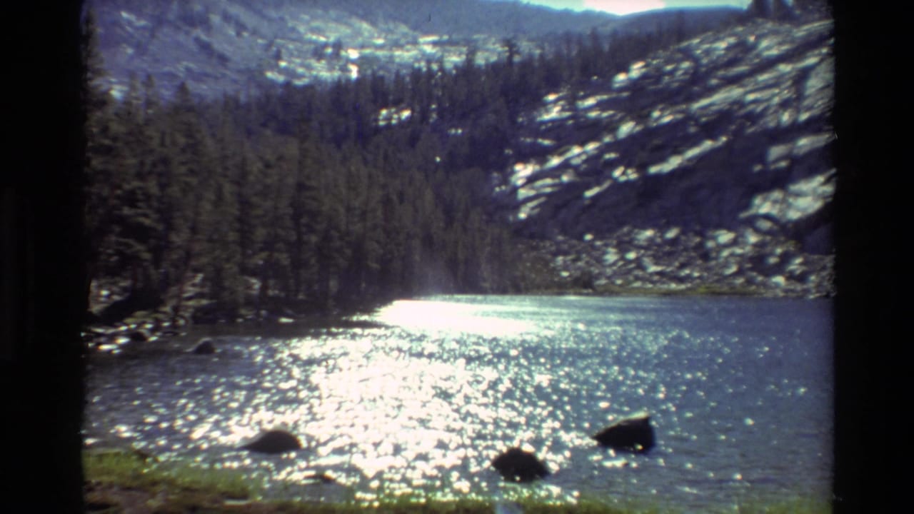 1981 8mm home-movie view of a clear mountain lake in the listed British Columbia location, with sunlight glinting on rippled water.