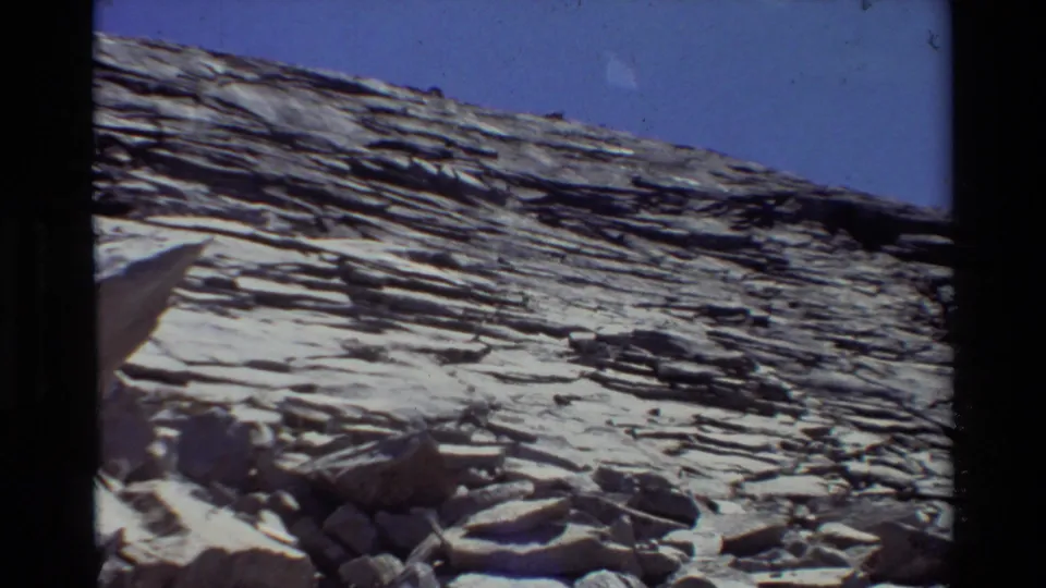 Wide 1981 8mm view of a sloped rock formation with horizontal strata and blue sky above, based on supplied location metadata.