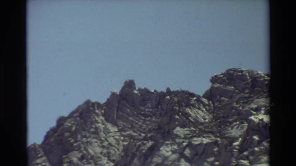 Rocky mountain ridge and pale blue sky in a 1981 8mm home-movie frame from the listed British Columbia location.