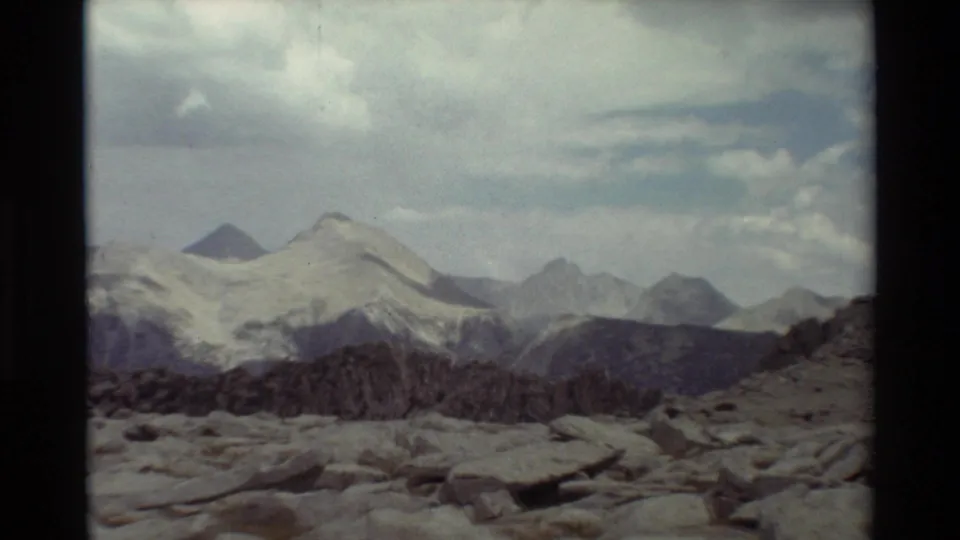 Final 8mm frame of the clip, with snow-marked alpine slopes, rugged rocks, and cloud cover in a British Columbia landscape per metadata.