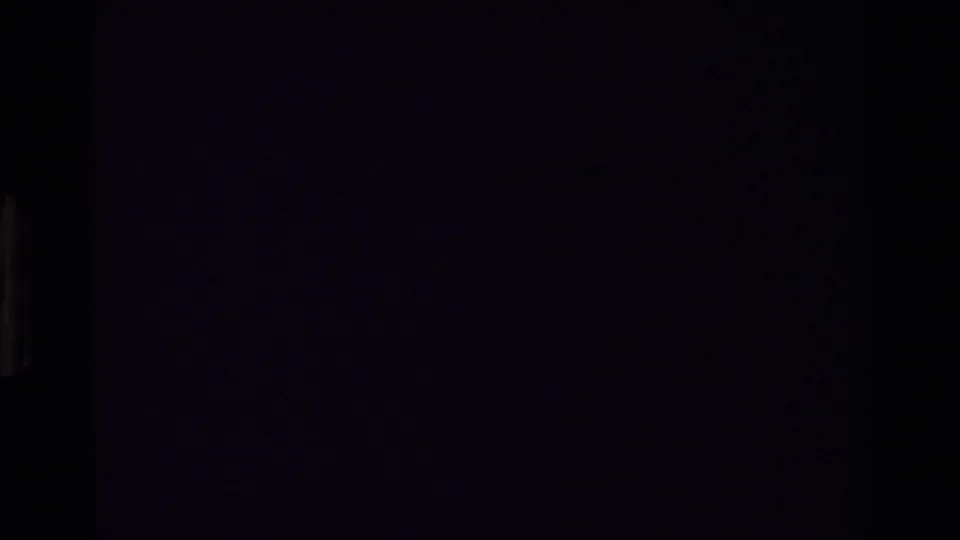 Dark 8mm frame with minimal visible detail, likely an exposure drop or transition within the reported mountain rescue reel.
