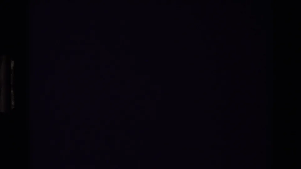 Nearly black final 8mm frame from the clip, showing only slight tonal variation and no identifiable figures or setting.