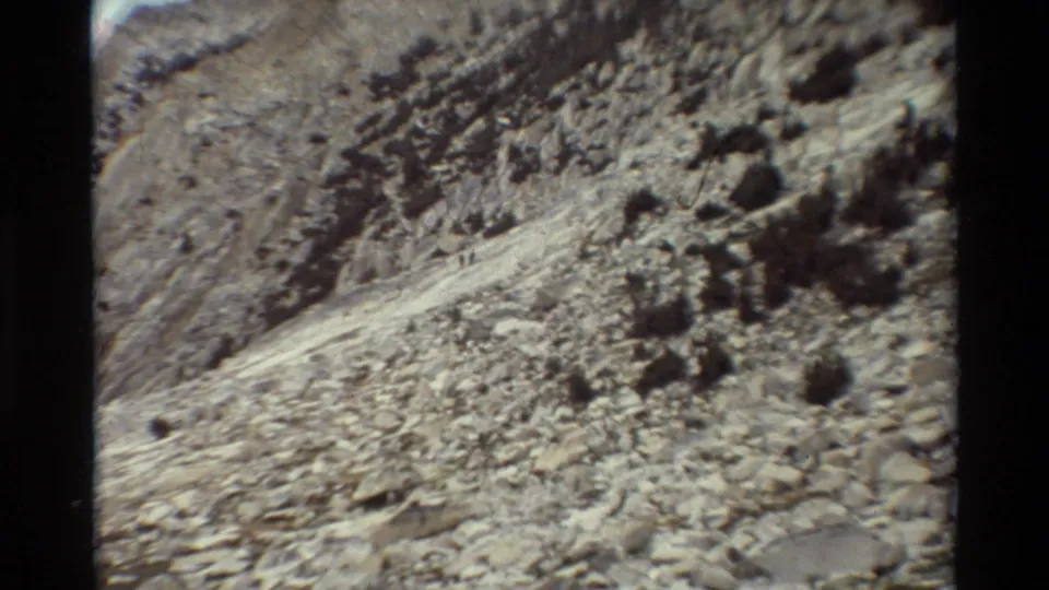 A grainy 8mm frame shows a rocky mountain slope and light trail in the listed British Columbia footage.