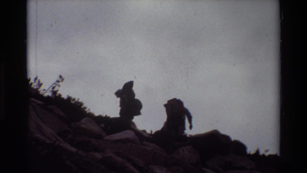 Two hikers with backpacks climb across rocky terrain in archival 8mm footage from the 1981 clip metadata.