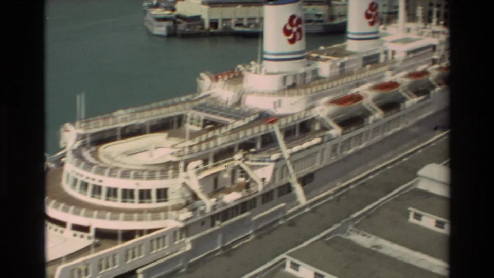 1981 Hawaii port frame showing a large white multi-deck passenger ship docked by the water, with red funnel logos visible.