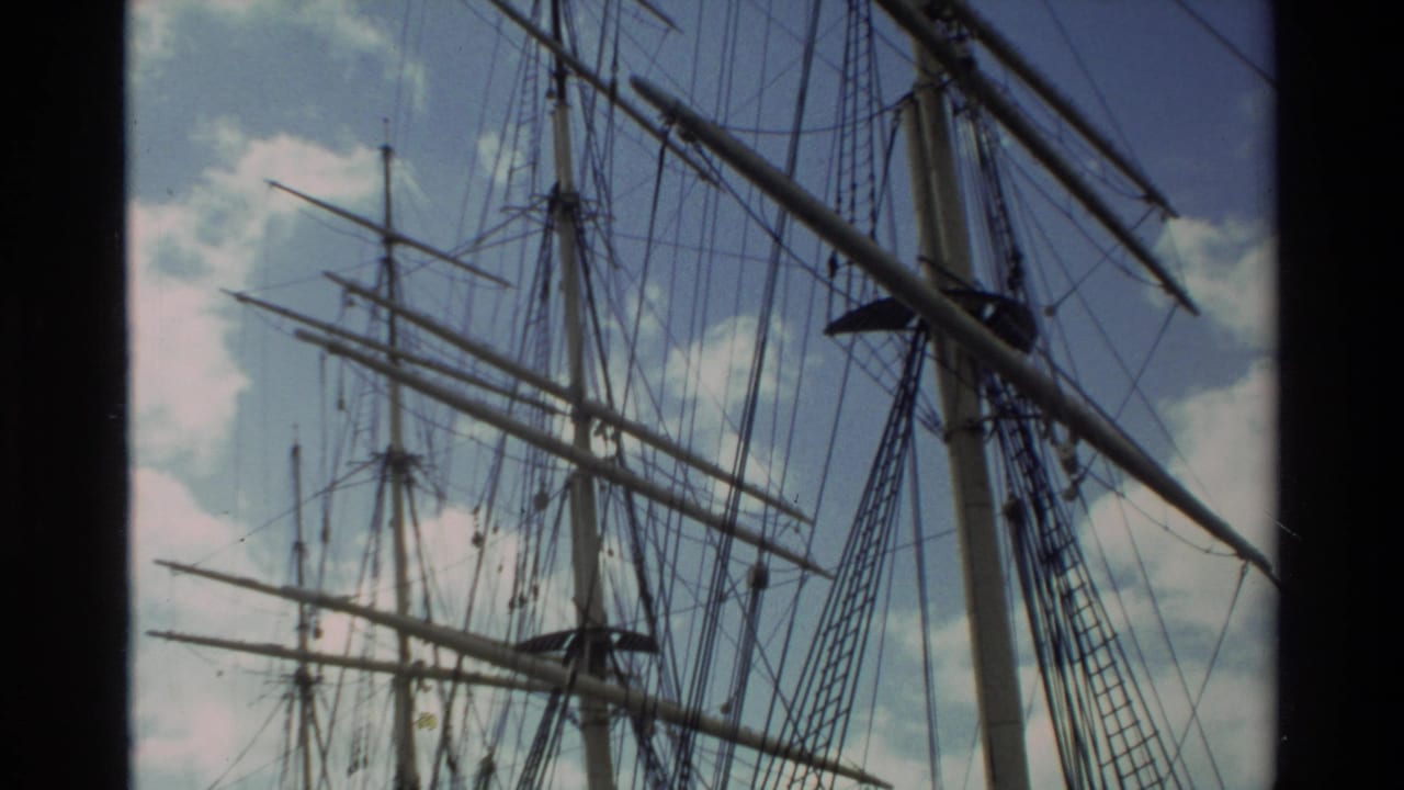 Tall ship rigging and mast details seen from below against clouds.
