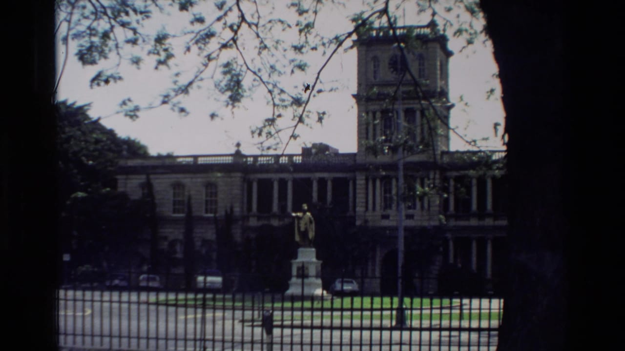 1981 Hawaii 8mm frame showing Aliiolani Hale, its clock tower, and the King Kamehameha I statue from outside the grounds.