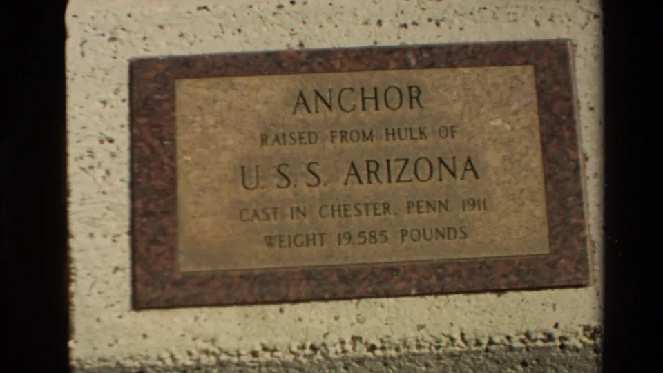 Close 8mm frame of a USS Arizona anchor plaque noting the anchor was raised from the ship's hull and cast in Chester, Pennsylvania.