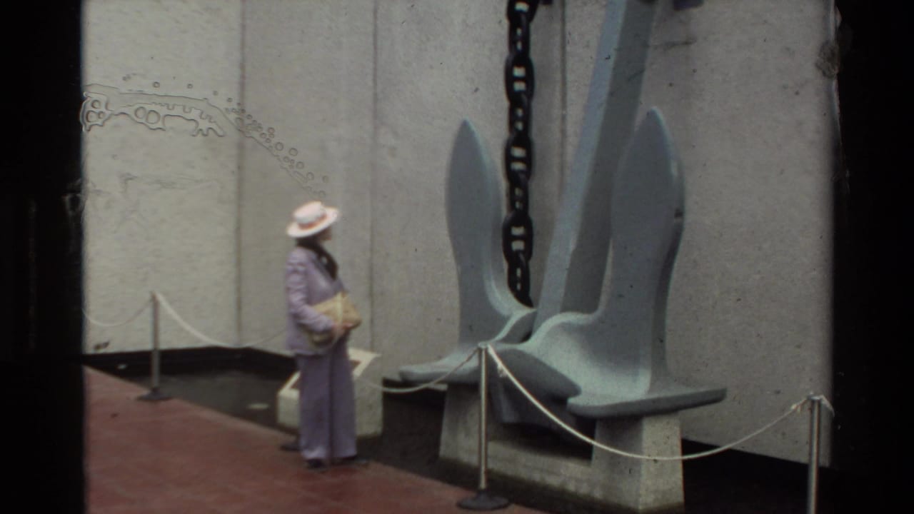1981 Hawaii home-movie frame showing a visitor near the USS Arizona anchor display at Pearl Harbor.