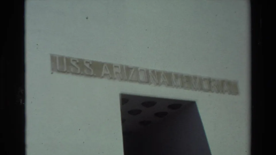 Soft 8mm view of the USS Arizona Memorial entrance in Hawaii, with the inscription above a dark doorway.