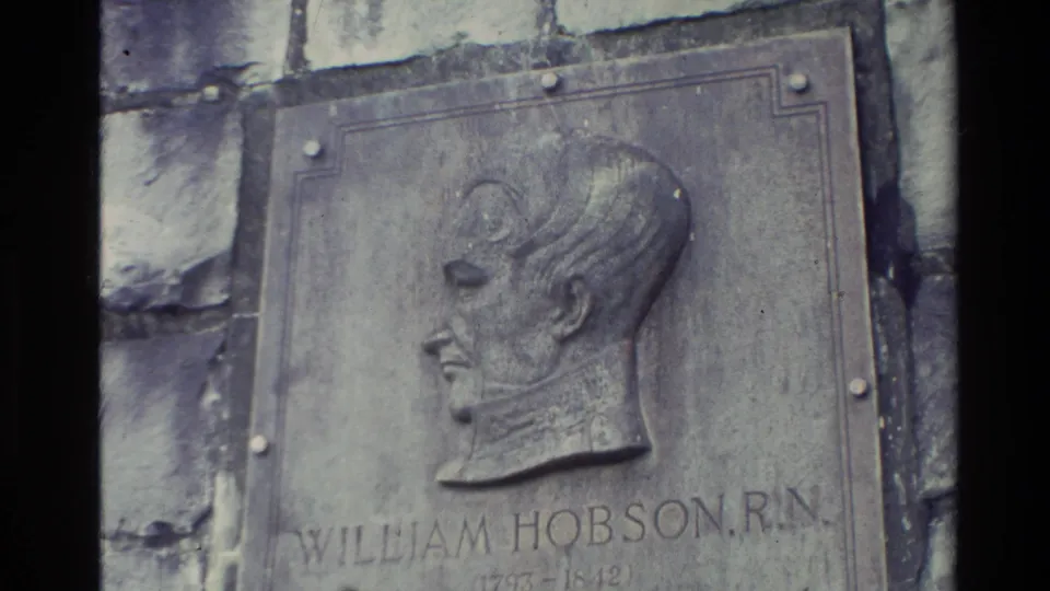 Close 1981 New Zealand home-movie view of a stone-mounted bronze plaque with a relief portrait labeled William Hobson, R.N.