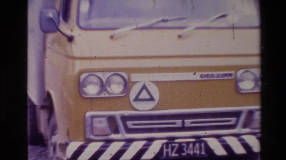 Front view of a yellow Forest Service van in 1981 New Zealand, showing headlights, triangular logo, striped bumper, and plate HZ 3441.