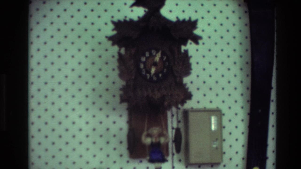 Second wooden wall clock with dark case, pendulum, and small wall box nearby.