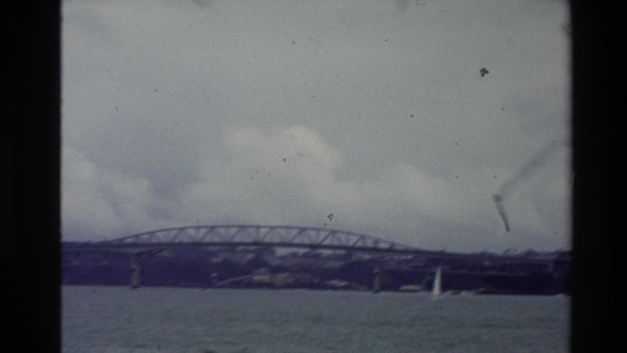 1981 New Zealand 8mm view of a truss bridge over water with a small white sailboat in the foreground.