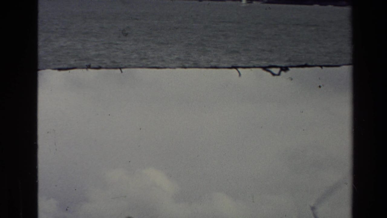 Overcast waterside view in a split 8mm frame with dark vertical film border.