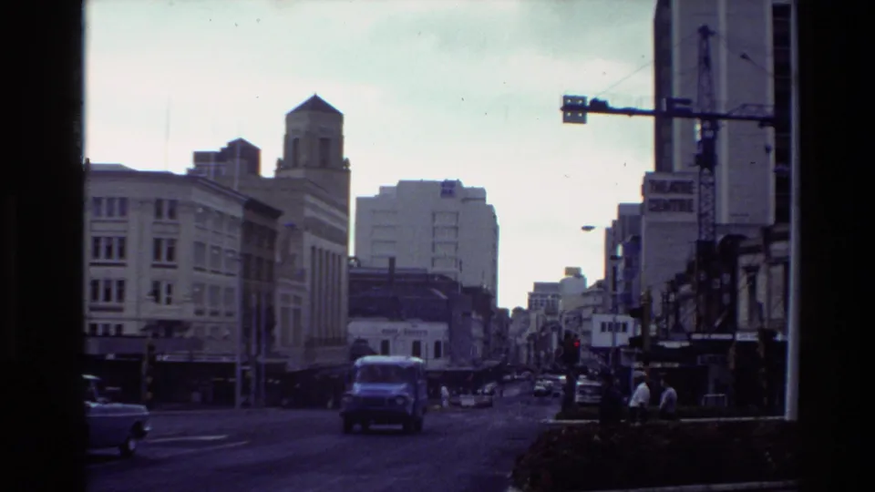 The 1981 New Zealand street view shows a blue van, cars, pedestrians, and downtown buildings near a visible Theatre Centre sign.