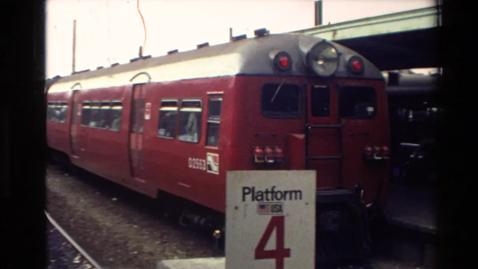 New Zealand 1981 station view with a red passenger train marked D2553 near a white Platform 4 sign and rail tracks.