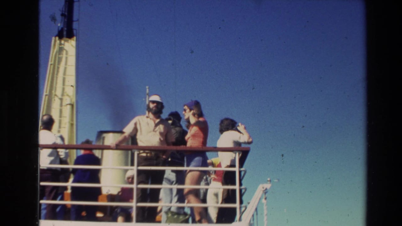 1981 New Zealand 8mm travel footage shows passengers on a vessel deck near metal railings, with a bright sky and ship structure visible.
