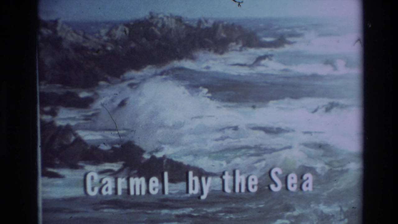 Rocky coastline with crashing surf and white Carmel-by-the-Sea title text.