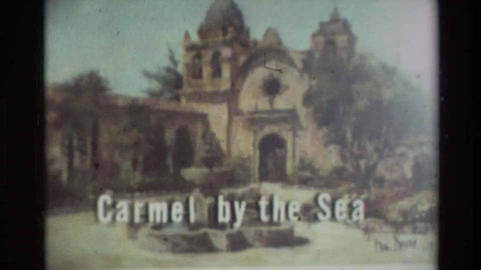 Soft 8mm frame of the Carmel by the Sea title graphic, with a mission-style facade and visible film divider.