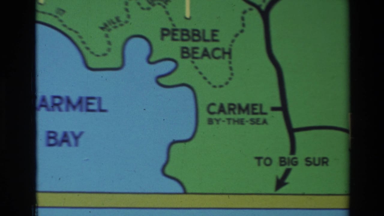 1982 Carmel-area travel map detail with blue bay, green land, Pebble Beach, Carmel-by-the-Sea, and a Big Sur direction arrow.