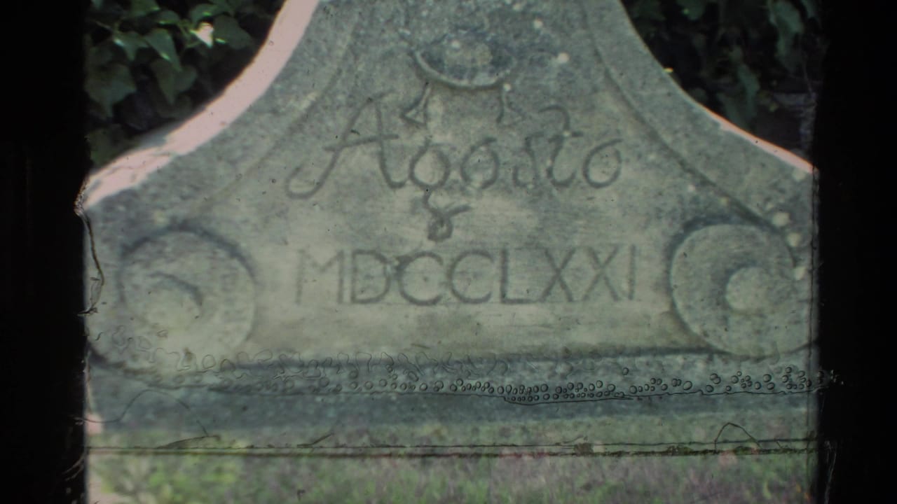 Carved stone marker with the inscription Agosto MDCCCLXXI partly visible beside dark foliage.