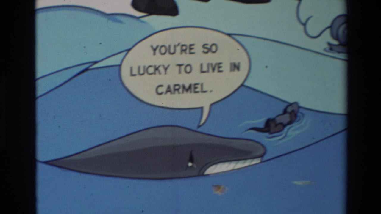 1982 Carmel 8mm frame of a hand-drawn whale in water beside a speech balloon reading, "You're so lucky to live in Carmel."