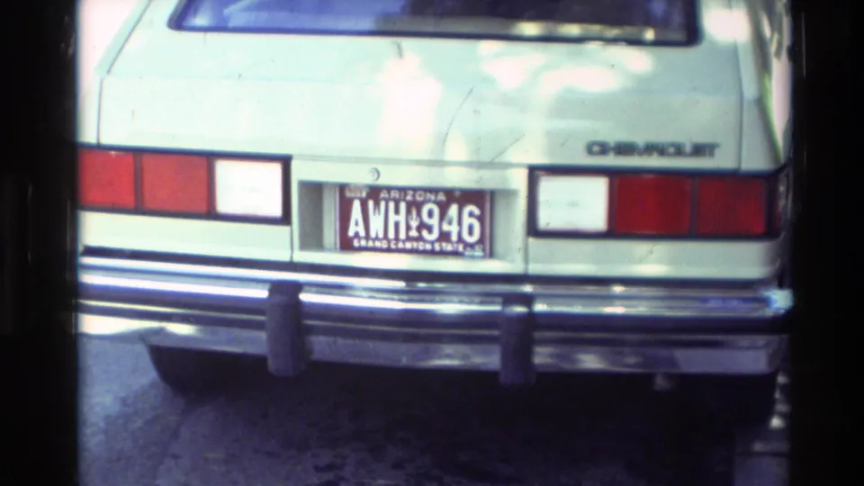 1982 Carmel frame showing an Arizona plate on a light-colored Chevrolet with rear lights and bumper visible.