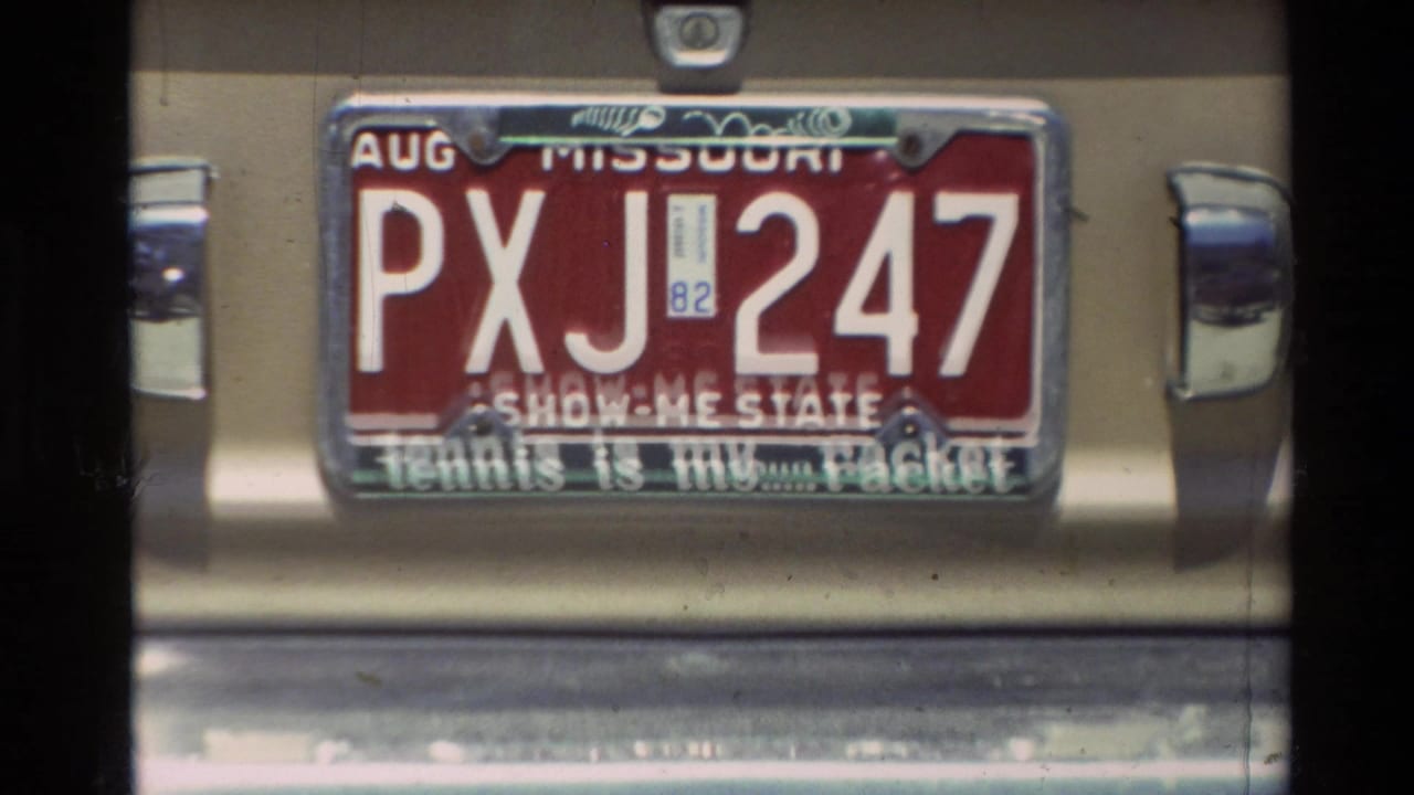 Close Super 8 view of a Missouri plate reading PXJ 247 on a rear bumper in the 1982 Carmel clip.