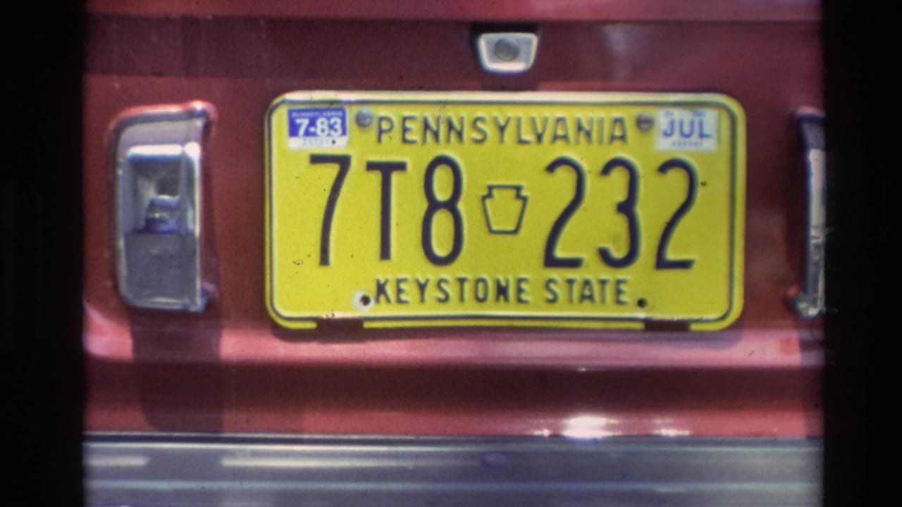 Yellow Pennsylvania Keystone State plate reading 7T8 232 on a red vehicle in the Carmel 1982 home-movie footage.
