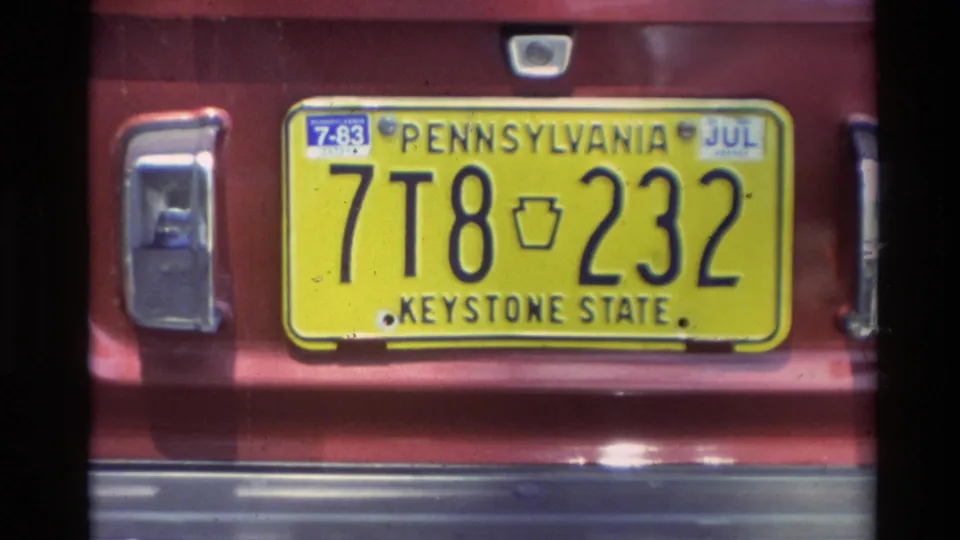 Yellow Pennsylvania Keystone State plate reading 7T8 232 on a red vehicle in the Carmel 1982 home-movie footage.