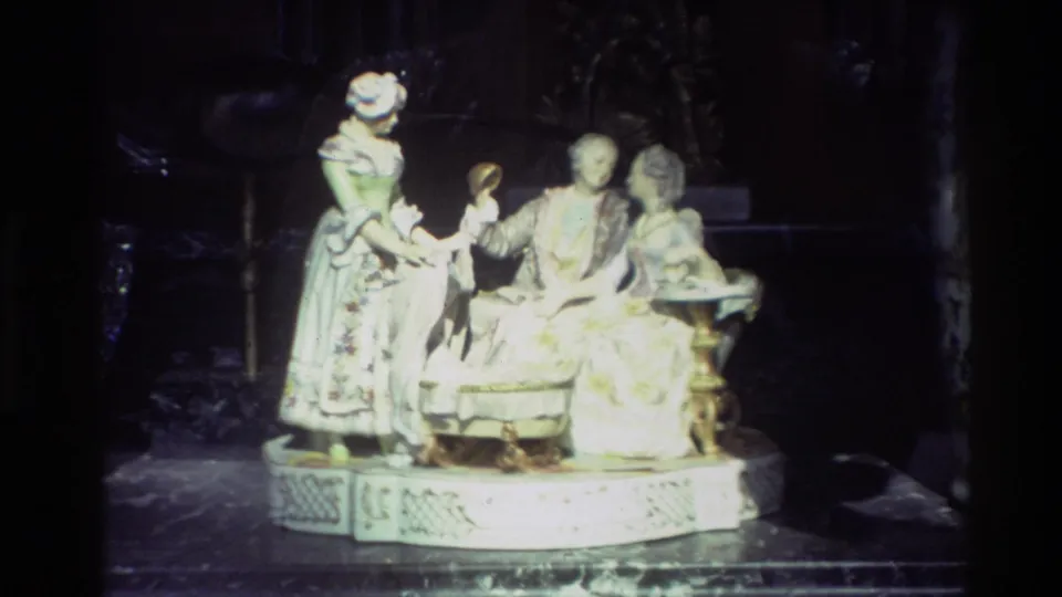 Close view of a white porcelain figure group in period-style clothing displayed inside a Carmel shop window in 1982.