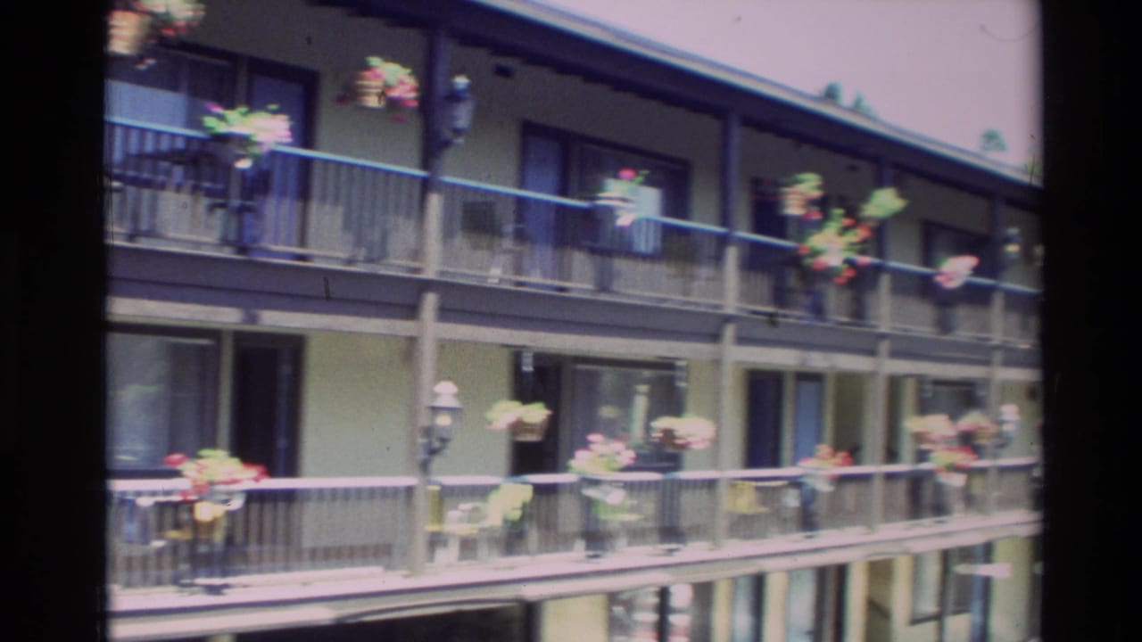 Apartment balconies with hanging flower baskets and dark railings.