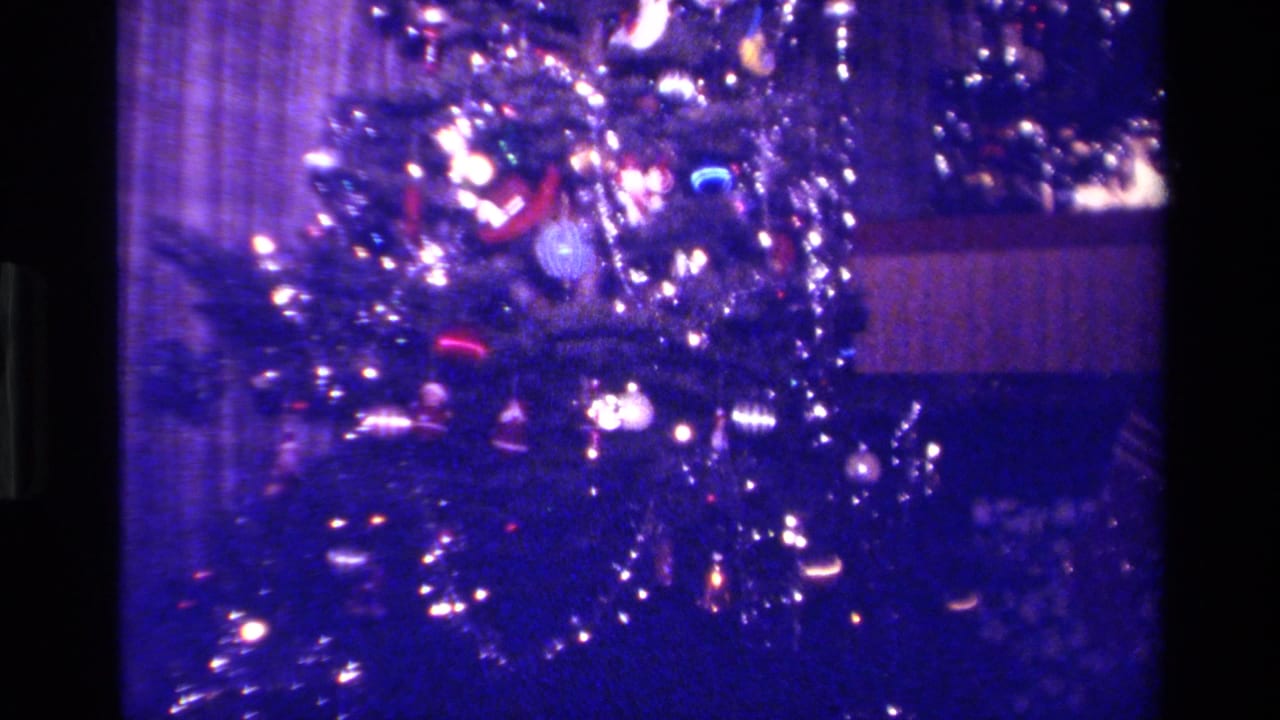 Close view of a Christmas tree covered with lights, ornaments, and tinsel.