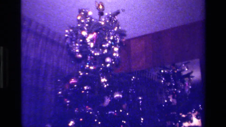 A tall holiday tree with tinsel and bright lights appears in a softly exposed 1979 California 8mm home movie frame.