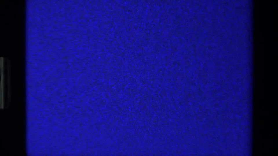 Blue-tinted 8mm frame with visible grain and little subject detail, likely between ornament views at the end of the clip.