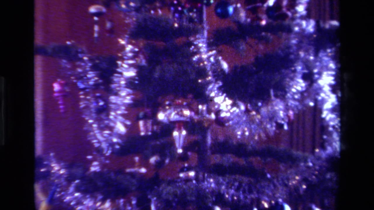 1979 California home-movie close-up of a Christmas tree with heavy silver tinsel, colored ornaments, and visible 8mm grain.