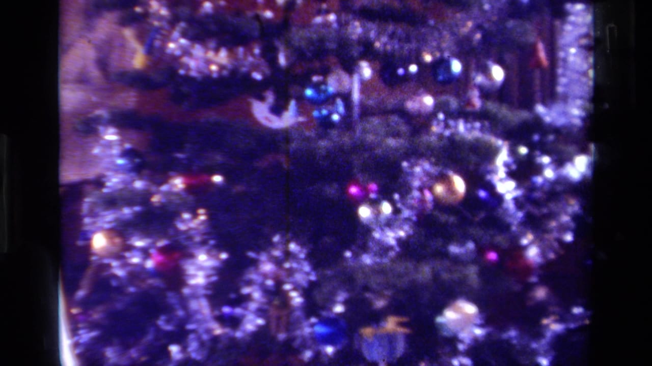 1979 California Super 8 frame with a decorated Christmas tree, silver tinsel, reflective ornaments, and visible film grain.