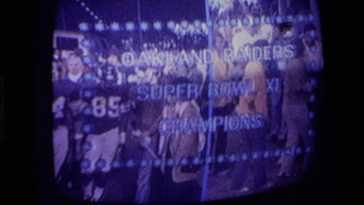 1970s California 8mm frame of a CRT television showing Oakland Raiders Super Bowl XI Champions text over players.